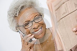 Cheerful Senior Woman Studying Stocks And Shares In Newspaper