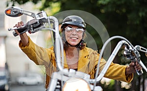 Cheerful senior woman traveller with motorbike in town.
