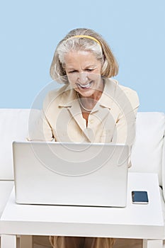 Cheerful senior woman using laptop for video calling