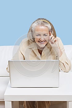 Cheerful senior woman using laptop for video calling