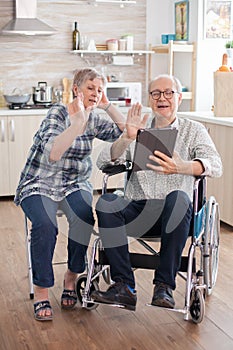 Cheerful senior woman waving on video conference