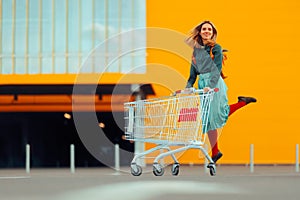 Cheerful Shopper Jumping with Joy Pushing Shopping Cart