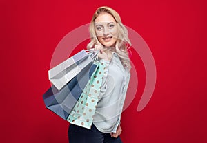 Cheerful shopping woman holding package bag with purchases after shopping, isolated on white background