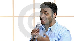 Cheerful showman talking into microphone.