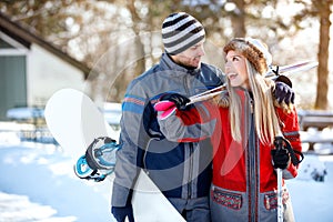 Cheerful skiers couple going to ski terrain