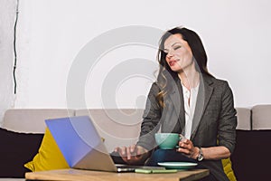 Cheerful skilled middle aged life or business coach enjoying creative process of making new text, sitting at workspace, writing
