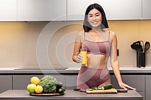 Cheerful Slim Japanese Woman Drinking Juice Cooking Dinner In Kitchen