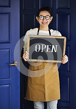 A cheerful small business owner with open sign