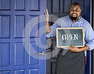 A cheerful small business owner with open sign photo