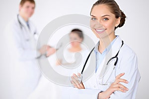 Cheerful smiling female doctor on the background with doctor and his patient in the bed. High level and quality of