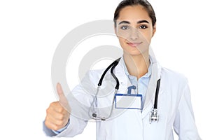 Cheerful smiling female doctor showing thumbs up, isolated over white background. Latin american or Hispanic young woman