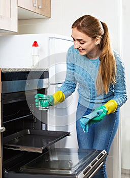 Cheerful smiling glad adult girl removing snuff in oven