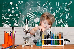 Cheerful smiling little boy having fun against blue wall. First grade. Science and education concept. My chemistry