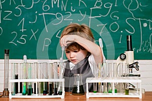 Cheerful smiling little boy having fun against blue wall. Home schooling. Lesson Plans - Middle School Chemistry. A