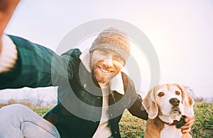 Cheerful smiling Man takes selfie photo with his best friend beagle dog during walking. Human and pets concept image