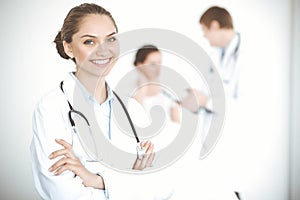 Cheerful smiling woman-doctor on the background of his patient in the bed. Medicine concept