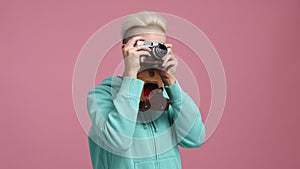 Cheerful, smiling woman taking pictures in the studio