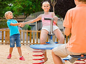 kids are teetering on the swing on the playground. photo