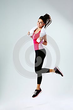 Cheerful sport woman with towel jumping