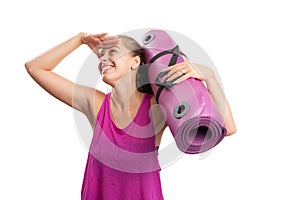 Cheerful sportive woman making searching gesture holding mat