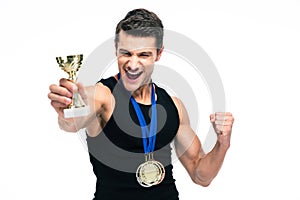 Cheerful sports man holding winner cup