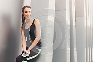 Cheerful sporty woman having rest after workout