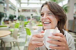 Cheerful student drinking coffee in the cafeteria