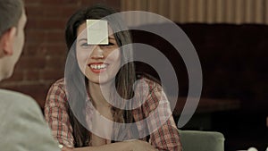 Cheerful students playing game with stickers on the foreheads