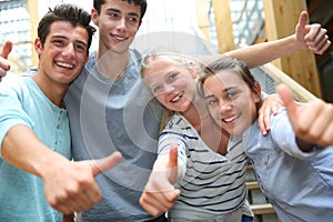 Cheerful students showing thumbs up