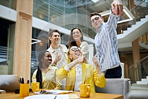 Cheerful students taking photo themselves indoors