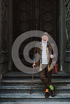 Cheerful stylish old man on urban background