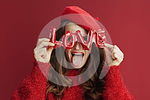 cheerful stylish woman with long wavy hair and love inscription