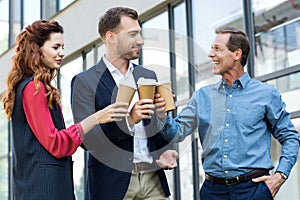 cheerful successful business team clinking with disposable cups