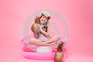 Cheerful summer girl with pineapple on colored background