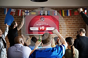 Cheerful supporters watching football at the pub