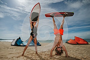 Cheerful surfing couple posing on the beach.