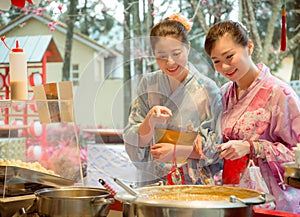 Cheerful sweet women friends pointing food stall