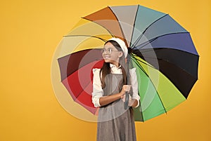 cheerful teen child under colorful parasol. kid in beret with rainbow umbrella.