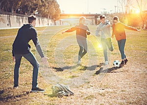 Cheerful teen friends playing with ball outdoors