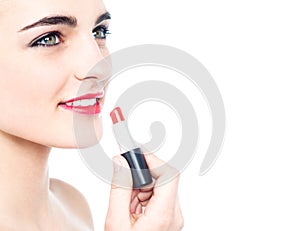 Cheerful teen girl applying red lipstick