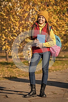 cheerful teen girl back to school in autumn. full length