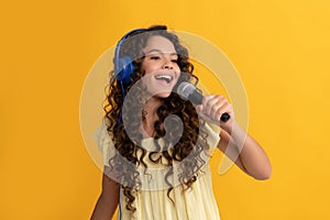cheerful teen girl listen music in headphones and singing in microphone, vocal school