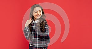 cheerful teen girl with long curly hair on red background, copy space, hairstyling