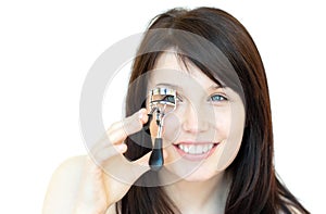 Cheerful teen girl using an eyelash curler