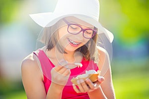 Cheerful teenage girl with dental braces glasses and ice cream. Portrait of a smiling pretty young girl in summer outfit with ice