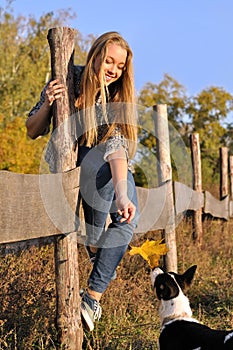 Cheerful teenage girl playing with outbred dog photo