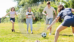 Cheerful teenagers are jogning with ball