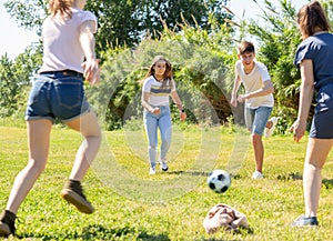 Cheerful teenagers are jogning with ball