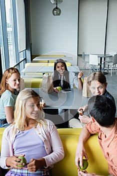 cheerful teenagers talking during lunch break