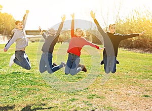 Cheerful teenages jumping in spring city park